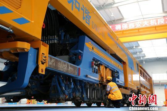 圖為工人正在清理大型養(yǎng)路機(jī)械。　張遠(yuǎn) 攝